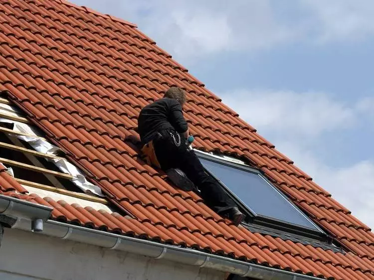 Robotnik montujący okno na dachu